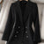 Triple-breasted black blazer for women with notched collar and button details.