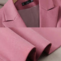 Pink long sleeve women's blazer with notched collar, triple-breasted closure, and straight fit design.