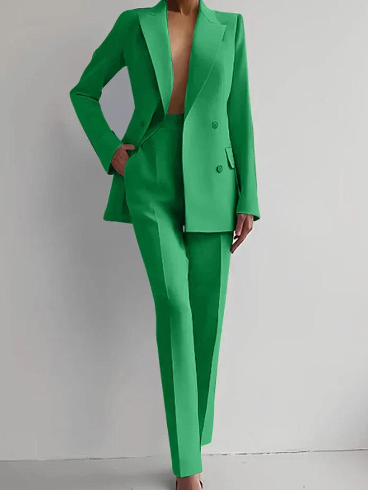 Women's green two piece blazer suit with long sleeves and pencil pants.