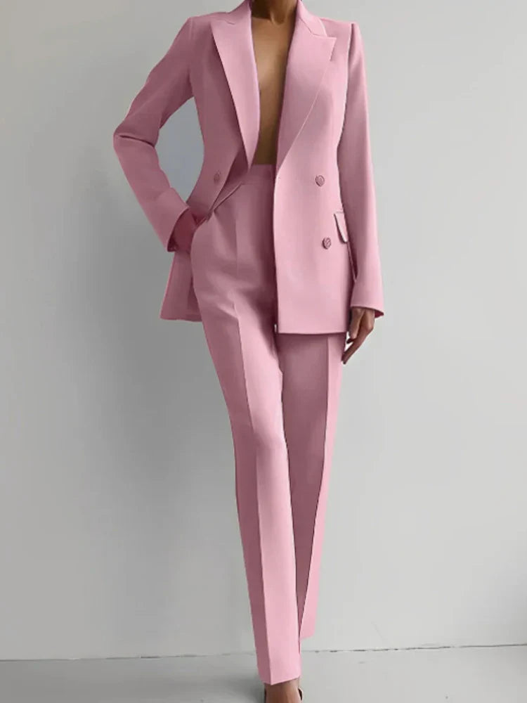 Two piece women's blazer suit in pink, double-breasted, long sleeve, with pencil pants.