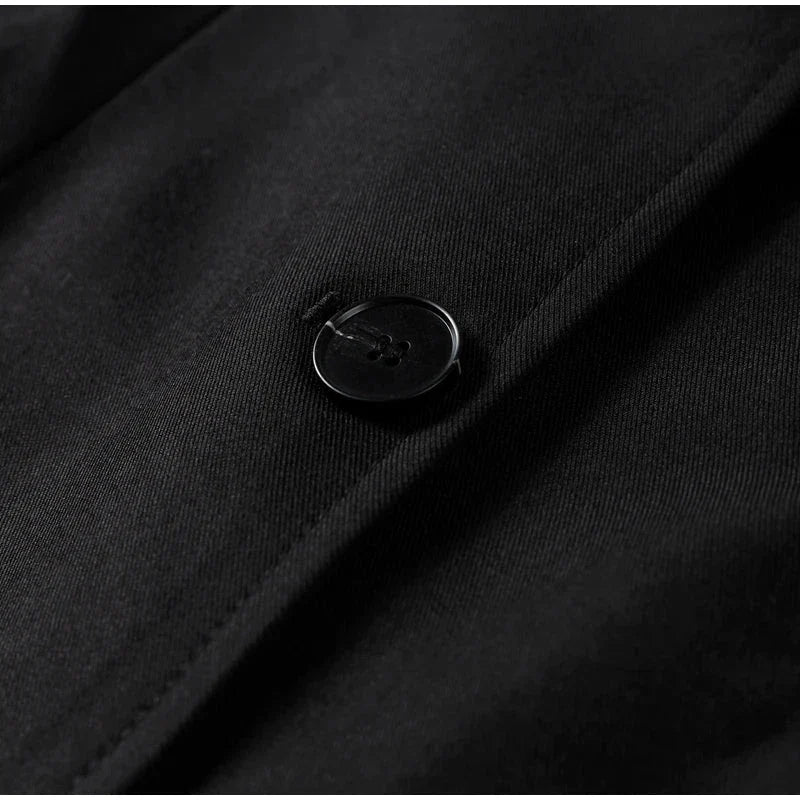 Close-up of single button on black women's blazer with slim lapel.