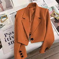 Women's loose solid color short suit jacket with notched collar and button decoration.