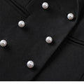 Close-up of a black triple-breasted blazer with pearl-like buttons.